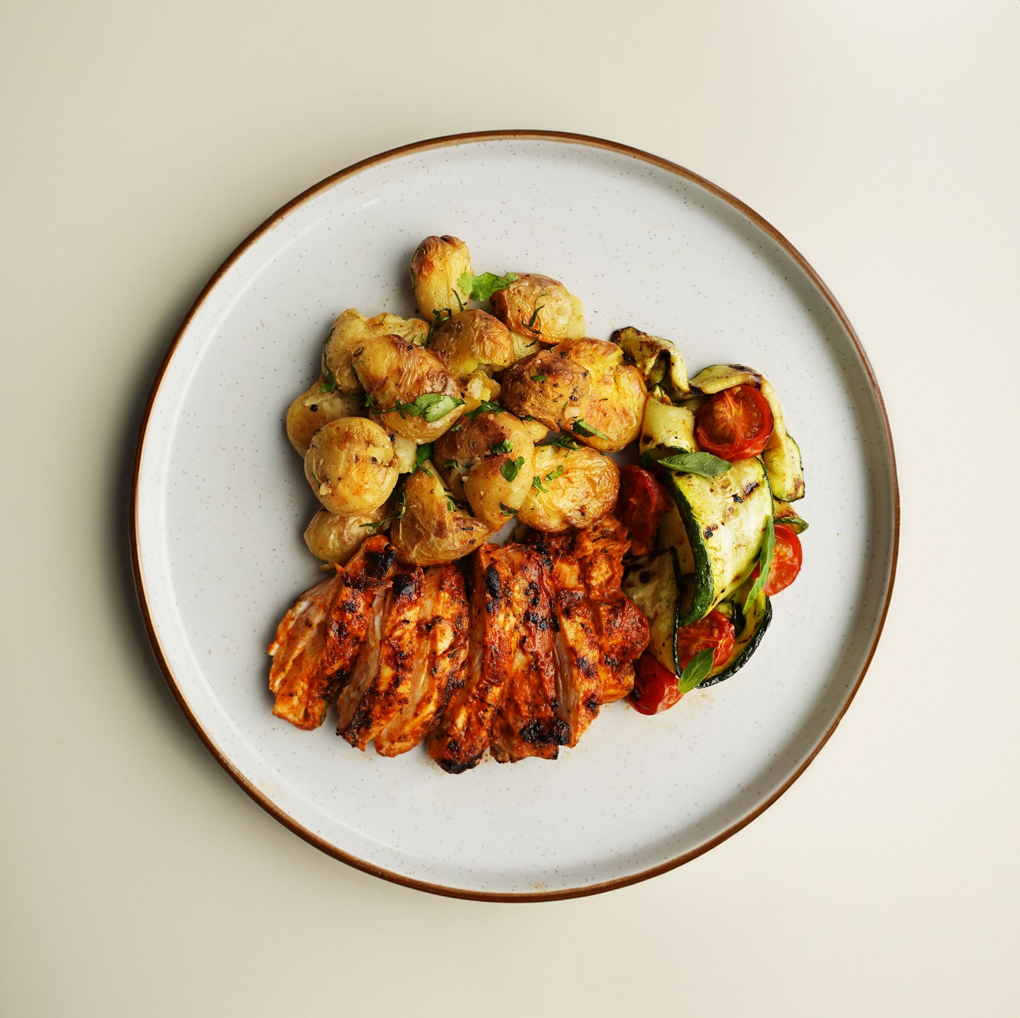 Harissa and Orange Chicken, Herb Crushed New Potato, Charred Courgette, Roasted Tomato, Basil and Lemon